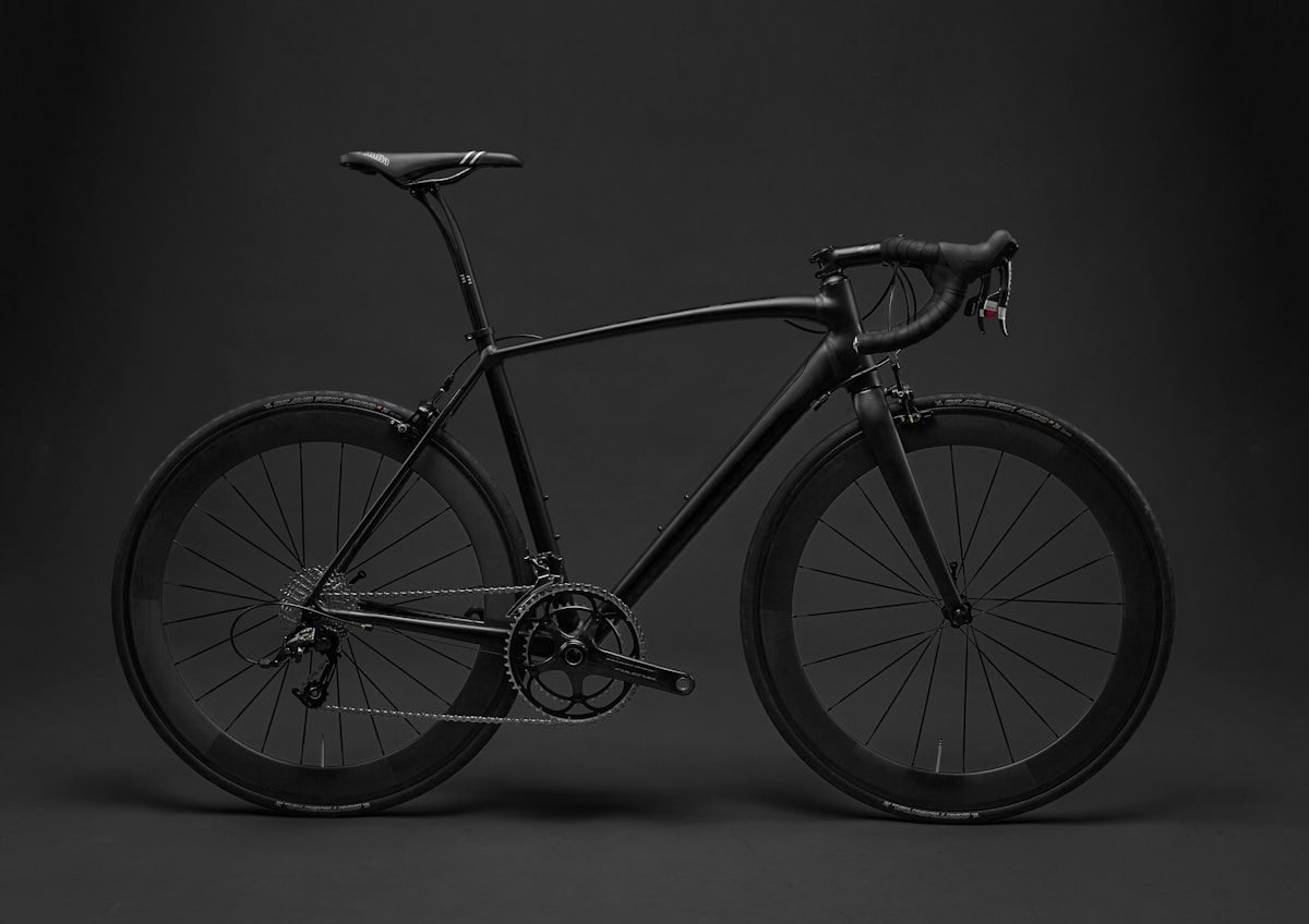 A matte black road bike photographed side-on showing its full frame geometry