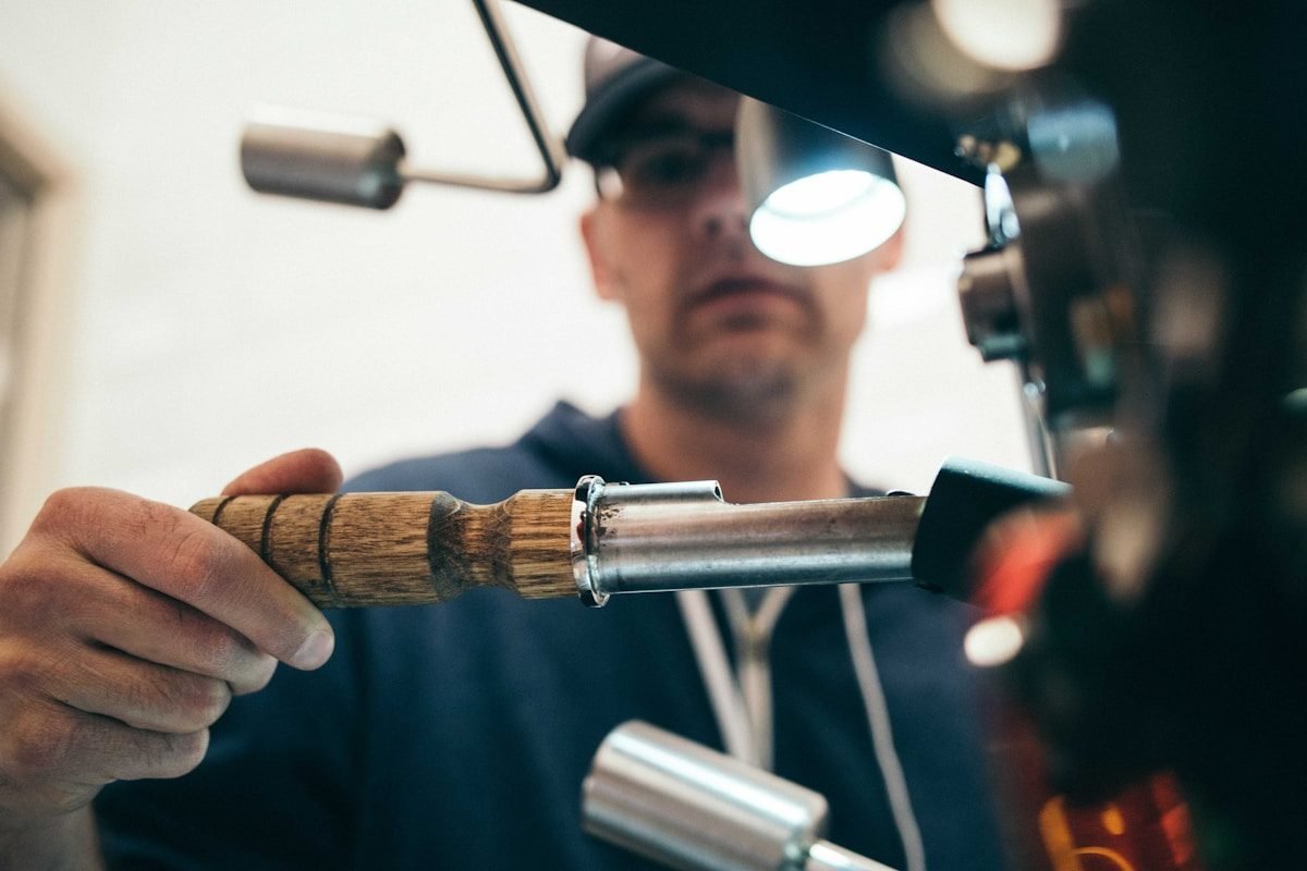 A mechanic holding bicycle workshop tools under a bright work light